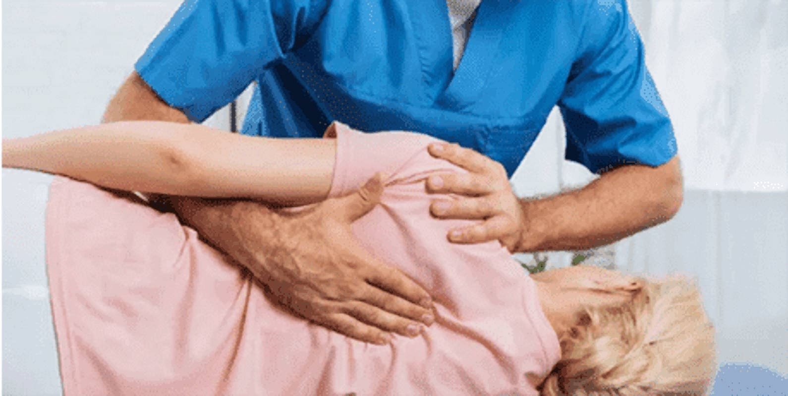 Dr. Nickels Augustine performing a targeted side-posture chiropractic adjustment on a woman to restore spinal alignment and relieve lower back pain.